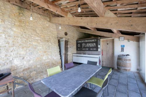 une table et des chaises dans une pièce avec un mur en pierre dans l'établissement Gîte l'olivier au mas Dujau, à Saint-Sauveur-de-Cruzières