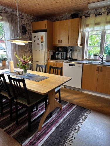a kitchen with a wooden table with chairs and a tableasteryasteryasteryasteryastery at Trehornahult Lillstugan in Burseryd