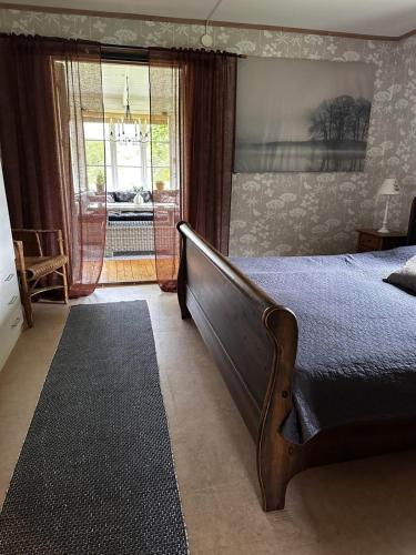 a bedroom with a large bed and a window at Trehornahult Lillstugan in Burseryd