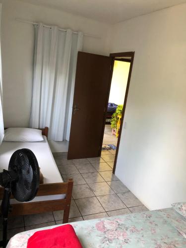 a room with two beds and a door with a mirror at Casa Vibra Luz Guest House Familiar in Florianópolis