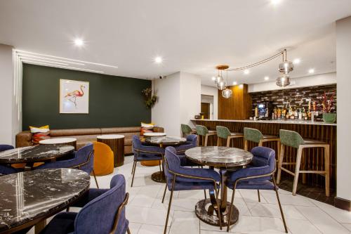 a restaurant with tables and chairs and a bar at voco Flagstaff by IHG in Flagstaff