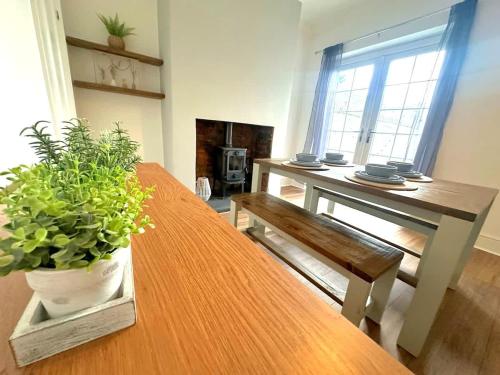 a living room with a wooden table and a bench and a table and a plant at Wrightson House by Blue Skies Stays in Stockton-on-Tees
