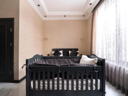 a black crib in a room with a window at Twin Villas Gabala in Gabala