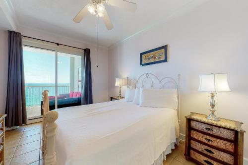Un dormitorio con una cama blanca y una ventana grande. en Island Royale P 501, en Gulf Shores