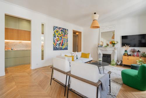 Elle comprend un salon doté d'un mobilier blanc et d'une cheminée. dans l'établissement Veeve - The Spirit Lifter, à Paris