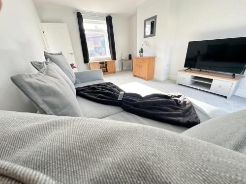 a living room with a bed and a flat screen tv at York House by Blue Skies Stays in Stockton-on-Tees
