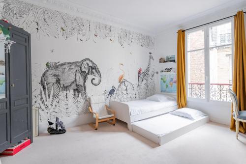 - une chambre avec une fresque murale représentant un éléphant dans l'établissement Veeve - The Spirit Lifter, à Paris