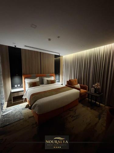 a bedroom with a large bed and a couch at شقق نوراليا للشقق المخدومة in Al Khobar