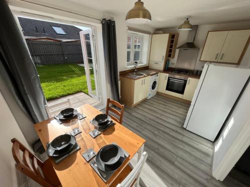 a kitchen and dining room with a table and a refrigerator at Coral House by Blue Skies Stays in Thornaby on Tees