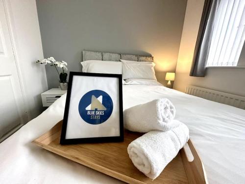 a bed with a wooden tray with a sign on it at Alma House by Blue Skies Stays in Hartlepool