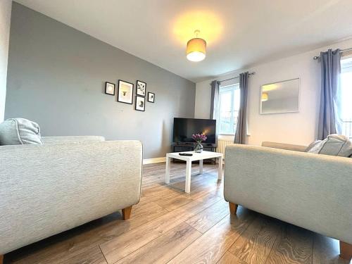 a living room with two couches and a tv at Alma House by Blue Skies Stays in Hartlepool