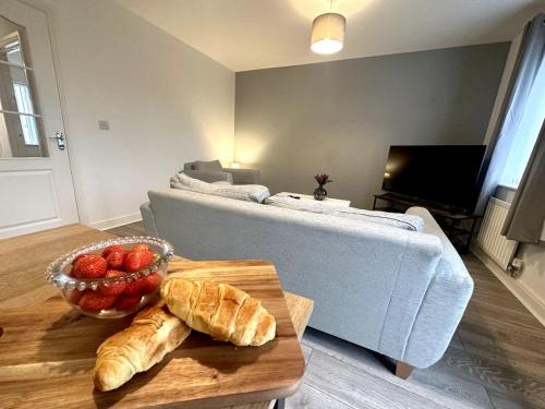 a living room with a couch and a table with a bowl of bread at Alma House by Blue Skies Stays in Hartlepool