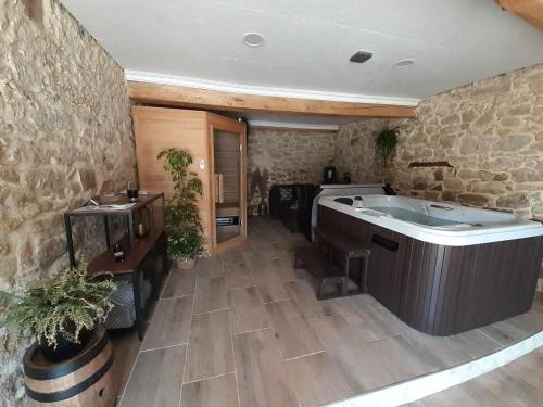 un ampio bagno con vasca in un muro di pietra di L'atelier Détente et Spa a Caudrot
