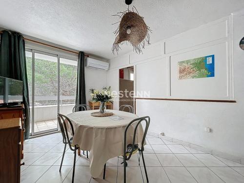d'une salle à manger avec une table, des chaises et une fenêtre. dans l'établissement 3143-T2 à 400m de la plage, à Argelès-sur-Mer
