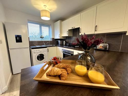 a table with two glasses of orange juice and croissants at Middlebeck House by Blue Skies Stays in Middlesbrough