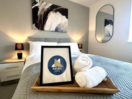 a bed with a tray with towels and a picture at Park House by Blue Skies Stays in Middlesbrough