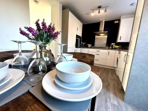 a kitchen with a table with bowls and plates on it at Park House by Blue Skies Stays in Middlesbrough