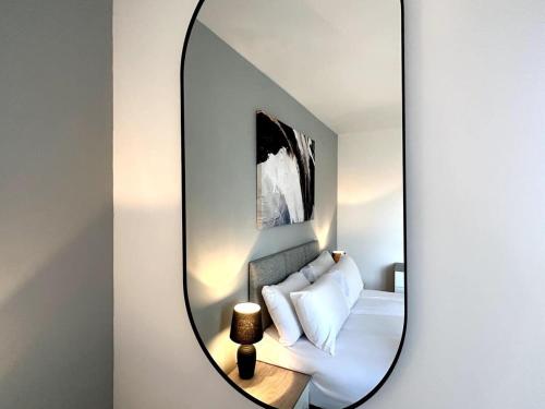 a mirror in a room with a bed and a couch at Park House by Blue Skies Stays in Middlesbrough