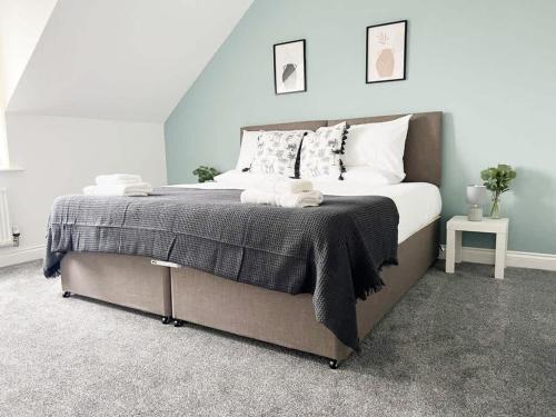 a bedroom with a large bed with a blue wall at Duxford House by Blue Skies Stays in Middlesbrough