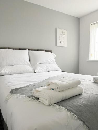 a white bed with two white towels on it at Duxford House by Blue Skies Stays in Middlesbrough