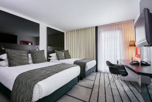 a hotel room with two beds and a desk at Crowne Plaza Manchester City Centre by IHG in Manchester