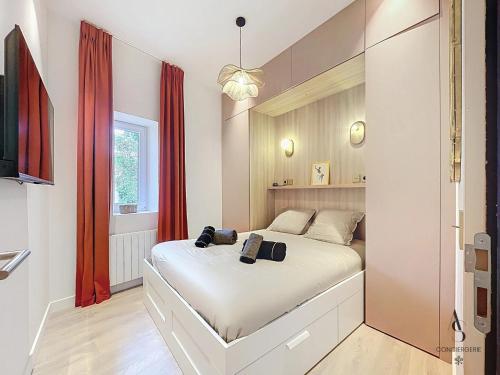 - une chambre avec un lit blanc et des rideaux rouges dans l'établissement Le Forville 4 pers 55m2 5 min Palais Suquet, à Cannes
