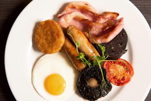 a plate of breakfast food with bacon and eggs at Crowne Plaza Manchester City Centre by IHG in Manchester