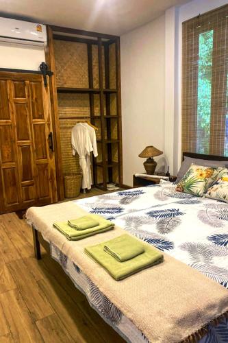 a bedroom with a bed with green towels on it at Colibri Beach Resort in Chaloklum