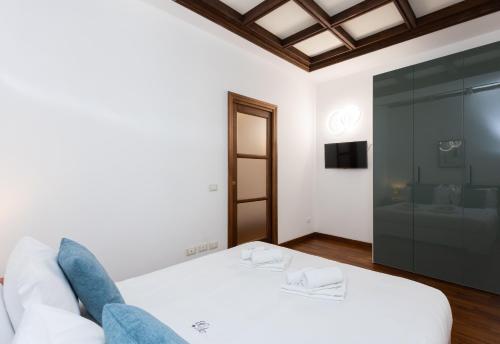 a bedroom with a white bed and a glass wall at Vicolo Trevi Apartment by Rental in Rome in Rome