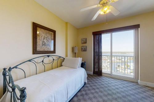 Un dormitorio con una cama con ventilador de techo y una ventana. en Island Royale P 406, en Gulf Shores