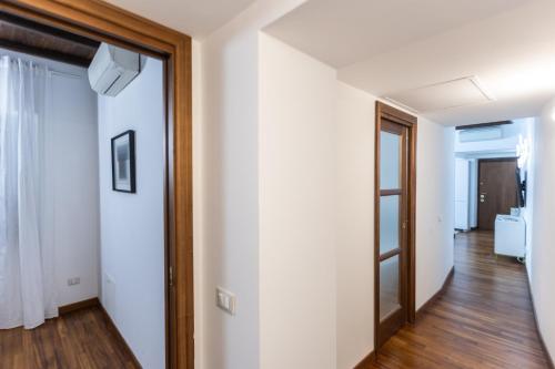 a hallway with white walls and a wooden door at Vicolo Trevi Apartment by Rental in Rome in Rome