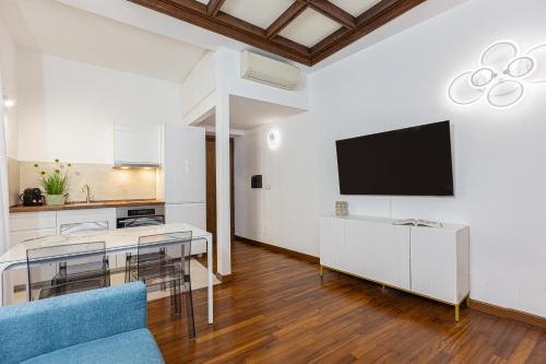 a living room with a table and a tv on a wall at Vicolo Trevi Apartment by Rental in Rome in Rome
