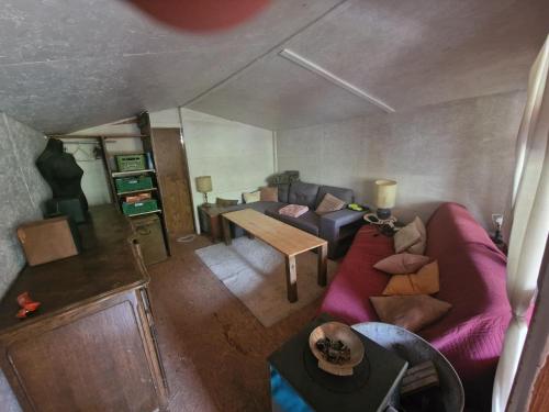 un salon avec un canapé violet et une table dans l'établissement Yourte cosy en pleine nature, proche Sainte-Baume, à Tourves