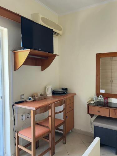 a room with a desk with a computer and a tv at Dora's apartment in Peroulades