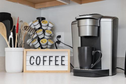 a coffee machine sitting next to a sign with coffee cups at Beach Vibes Villa - 3 Bedrooms in prime location near beach with private yard! in Myrtle Beach
