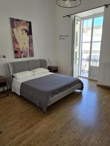 ein Schlafzimmer mit einem Bett und einem großen Fenster in der Unterkunft Madama in Bari