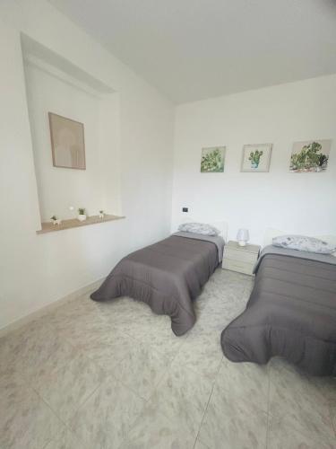 two beds in a room with white walls at Podere 48 - Relax tra mare e natura a Sabaudia - fino a 5 persone in San Donato