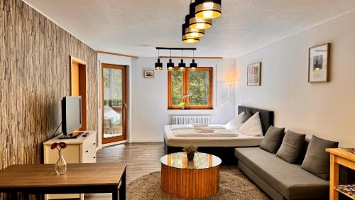 a living room with a couch and a bed at Waldtwin 1 Titisee (W11) + Hochschwarzwald Card in Titisee-Neustadt