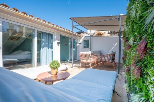 a patio with a couch and an umbrella and a table at Hostel Ozz Nice in Nice