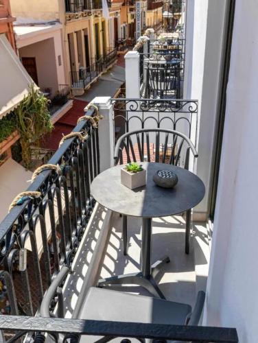 a table and chair on a balcony with a street at Metropolitan Pearl Boutique Hotel in Chania Town