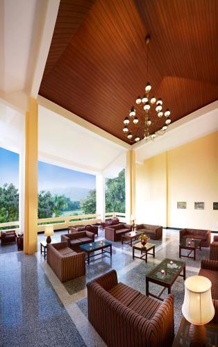a large lobby with couches and tables and a large window at Gir Serai - IHCL SeleQtions in Sasan Gir