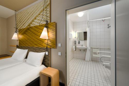a hotel room with a bed and a bathroom at ibis Hotel Hamburg St. Pauli Messe in Hamburg