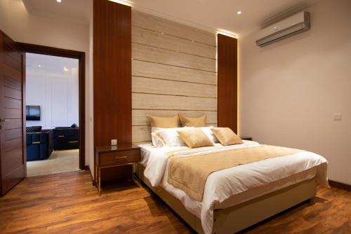 a bedroom with a large bed with a wooden headboard at King's Crown Hotel in Garifa