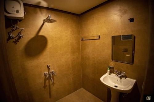 a bathroom with a sink and a mirror at King's Crown Hotel in Garifa