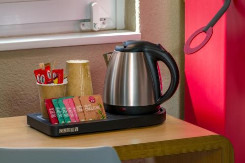 a tea kettle sitting on top of a table at ibis Hotel Hamburg St. Pauli Messe in Hamburg