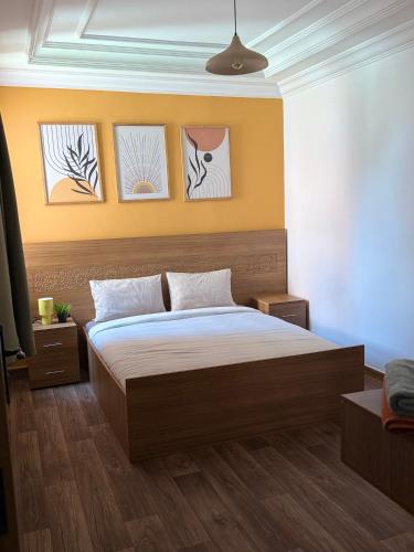a bedroom with a bed and paintings on the wall at Julie's AIRPORT Apartment in Marrakech