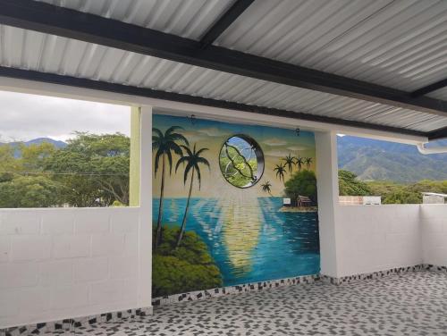 a mural on the side of a building with palm trees at Casa para vacaciones Neiva Rivera Huila in Rivera