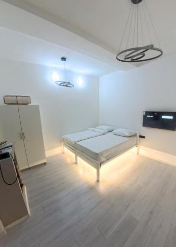 a white room with a bed and a flat screen tv at NEW - Old Town Pearl Apartments in Sarajevo