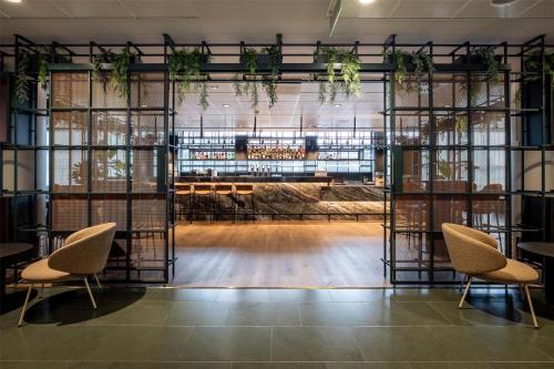 a room with a table and chairs and plants at Scandic Simonkenttä in Helsinki