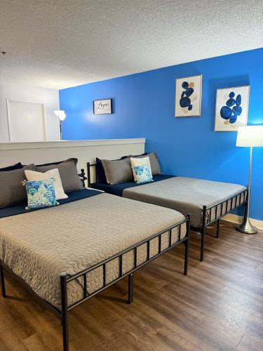 two beds in a room with a blue wall at Hollywood Blvd Studio FREE DESIGNATED PARKING & WIFI in Los Angeles
